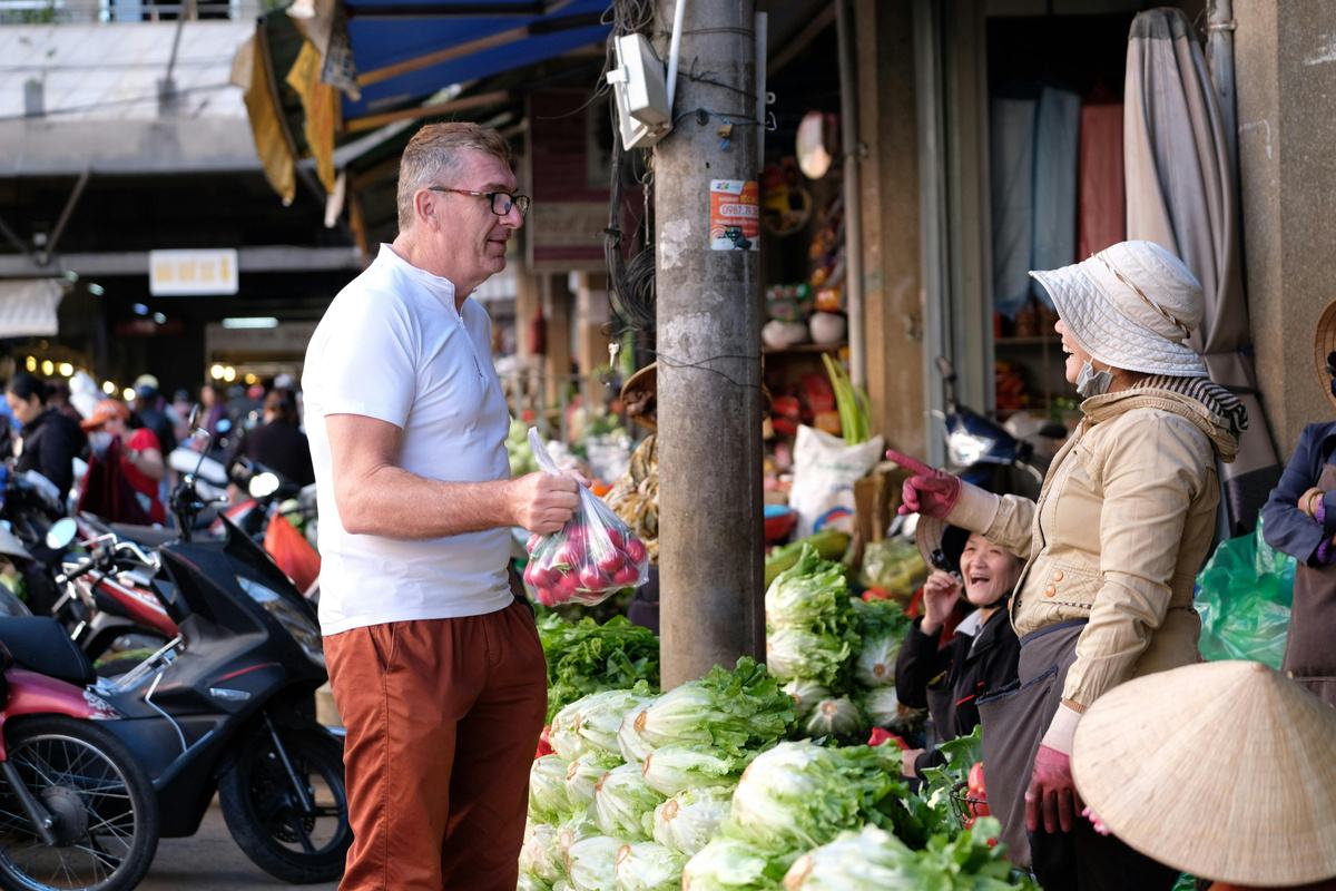 Traveler buying vegetables from a local market vendor